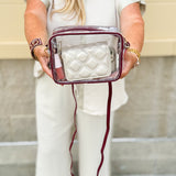 Clear crossbody purse with garnet vegan leather trim and brass hardware, designed for stadium approval and gameday style.