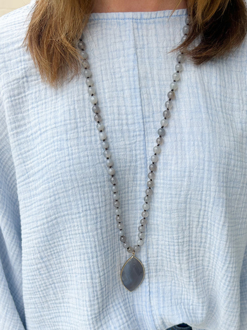Long necklace with grey agate pendant in natural stone design.
