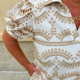 Cream mini dress with taupe geometric eyelet pattern, puffed sleeves, open collar, and side pockets