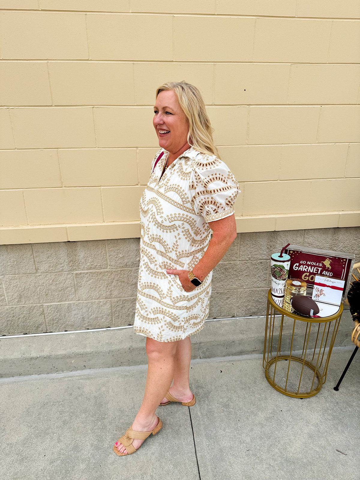Cream mini dress with taupe geometric eyelet pattern, puffed sleeves, open collar, and side pockets