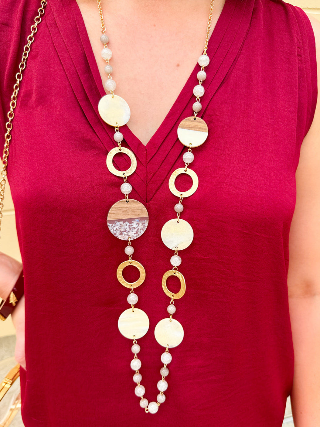 Long oatmeal-colored necklace with mixed circle and bead design, featuring neutral stones and delicate chain