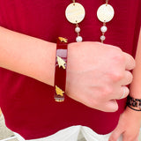 Garnet resin bangle with gold FSU logo charm on a white background