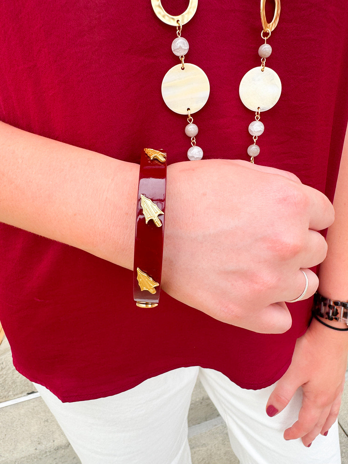 Garnet resin bangle with gold FSU logo charm on a white background