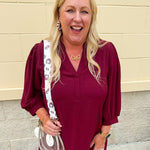Reversible garnet and gold FSU bag strap with floral print and stripes, featuring brass hardware.