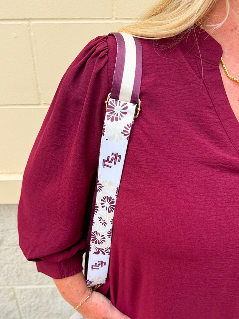 Reversible garnet and gold FSU bag strap with floral print and stripes, featuring brass hardware.