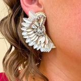 Gold and white feather-inspired earrings with a folded design and silver rhinestone cluster at the stud—lightweight with a bold, elegant look.