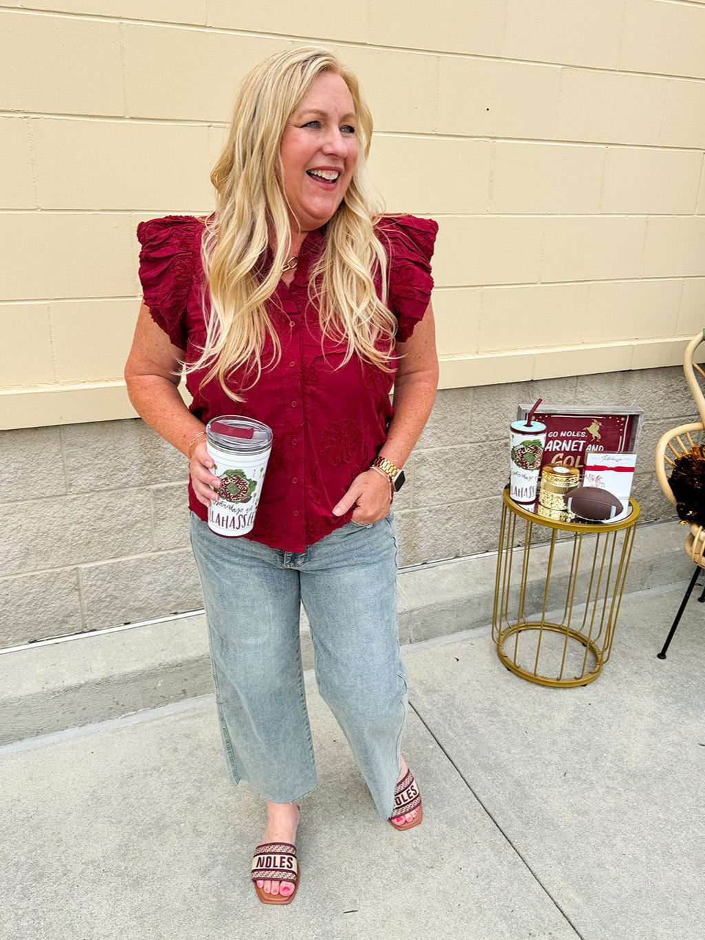 Garnet cotton flutter sleeve top with floral appliqué, ruffle V-neck, and button front—lightweight and perfect for gameday