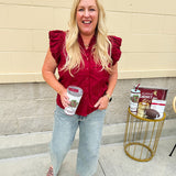Garnet cotton flutter sleeve top with floral appliqué, ruffle V-neck, and button front—lightweight and perfect for gameday
