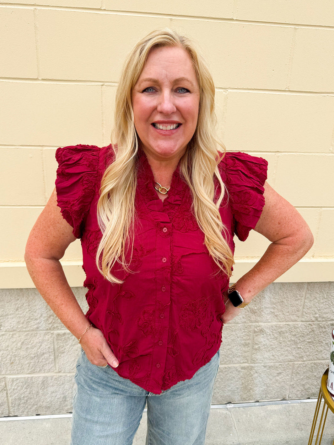 Garnet cotton flutter sleeve top with floral appliqué, ruffle V-neck, and button front—lightweight and perfect for gameday