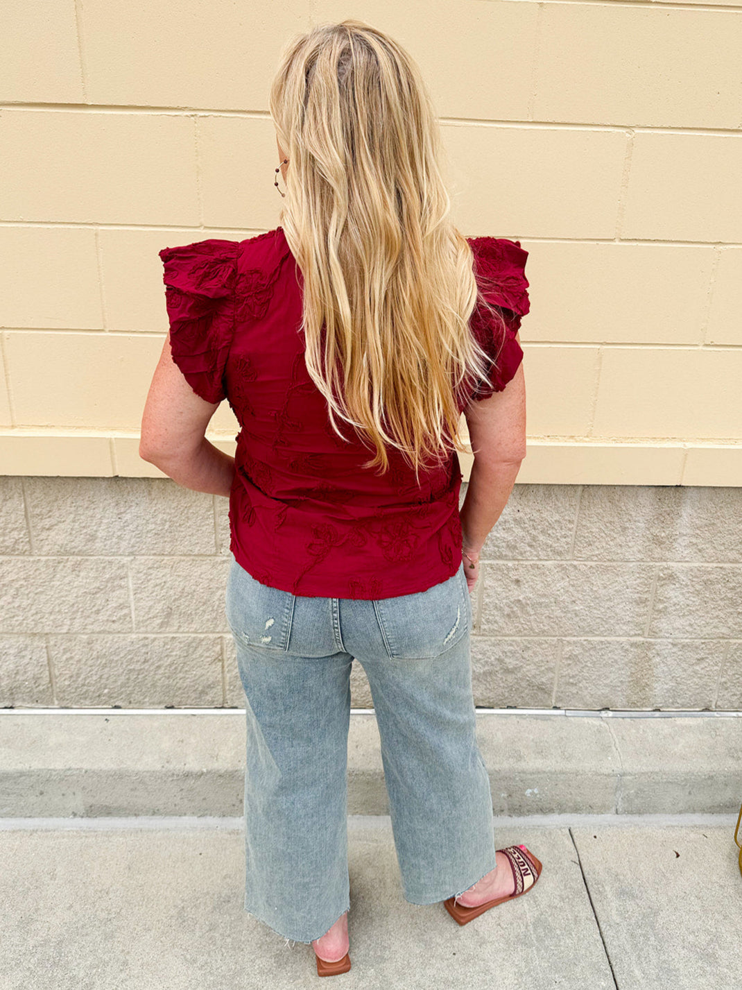 Garnet cotton flutter sleeve top with floral appliqué, ruffle V-neck, and button front—lightweight and perfect for gameday