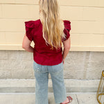 Model wearing light wash, cropped wide leg jeans with raw hem and light distressing. Jeans feature a mid-rise waist and tummy control panel.