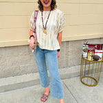 Cream and gold striped round-neck top with dolman sleeves and elastic cuffs, styled for summer.