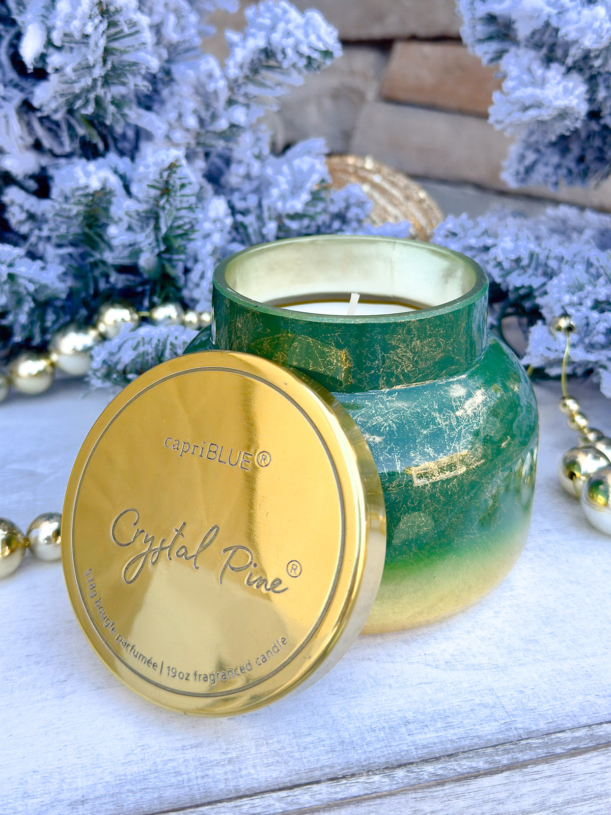 Capri Blue Glimmer Crystal Pine 19oz candle in green and gold ombré glass vessel.
