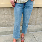Light wash mid-rise flare jeans with frayed hem and flattering fit, styled for casual and chic everyday looks.