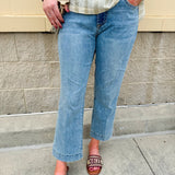 Light wash mid-rise flare jeans with frayed hem and flattering fit, styled for casual and chic everyday looks.