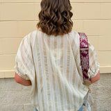 Cream and gold striped round-neck top with dolman sleeves and elastic cuffs, styled for summer.