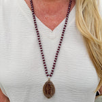 Long beaded necklace with alternating garnet and white beads, featuring a gold football pendant. A bold yet fun Gameday accessory.