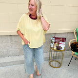 Golden yellow short sleeve blouse with a relaxed fit and dolman sleeves, styled for casual or dressy occasions.