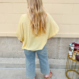 Golden yellow short sleeve blouse with a relaxed fit and dolman sleeves, styled for casual or dressy occasions.