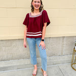Garnet square neck woven top with white contrast tape on neckline and hem—lightweight and stylish for FSU gameday