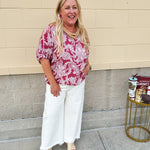 Lightweight garnet top with white paisley print, boat neckline, and loose dolman sleeves.