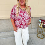 Lightweight garnet top with white paisley print, boat neckline, and loose dolman sleeves.
