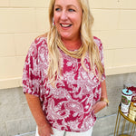 Lightweight garnet top with white paisley print, boat neckline, and loose dolman sleeves.