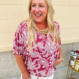 Lightweight garnet top with white paisley print, boat neckline, and loose dolman sleeves.
