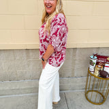 Lightweight garnet top with white paisley print, boat neckline, and loose dolman sleeves.