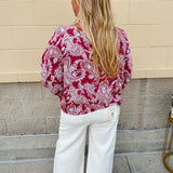 Lightweight garnet top with white paisley print, boat neckline, and loose dolman sleeves.