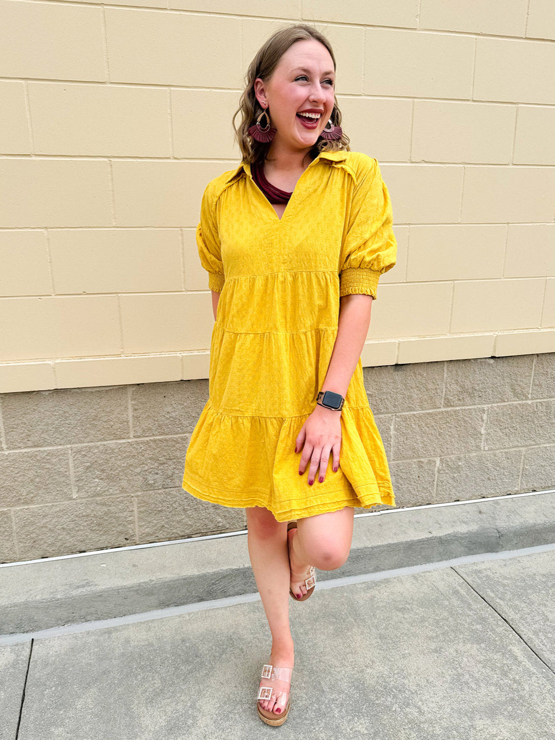Mustard cotton mini dress with a collar, tiered A-line shape, and smocked cuff balloon sleeves—perfect for gameday style.