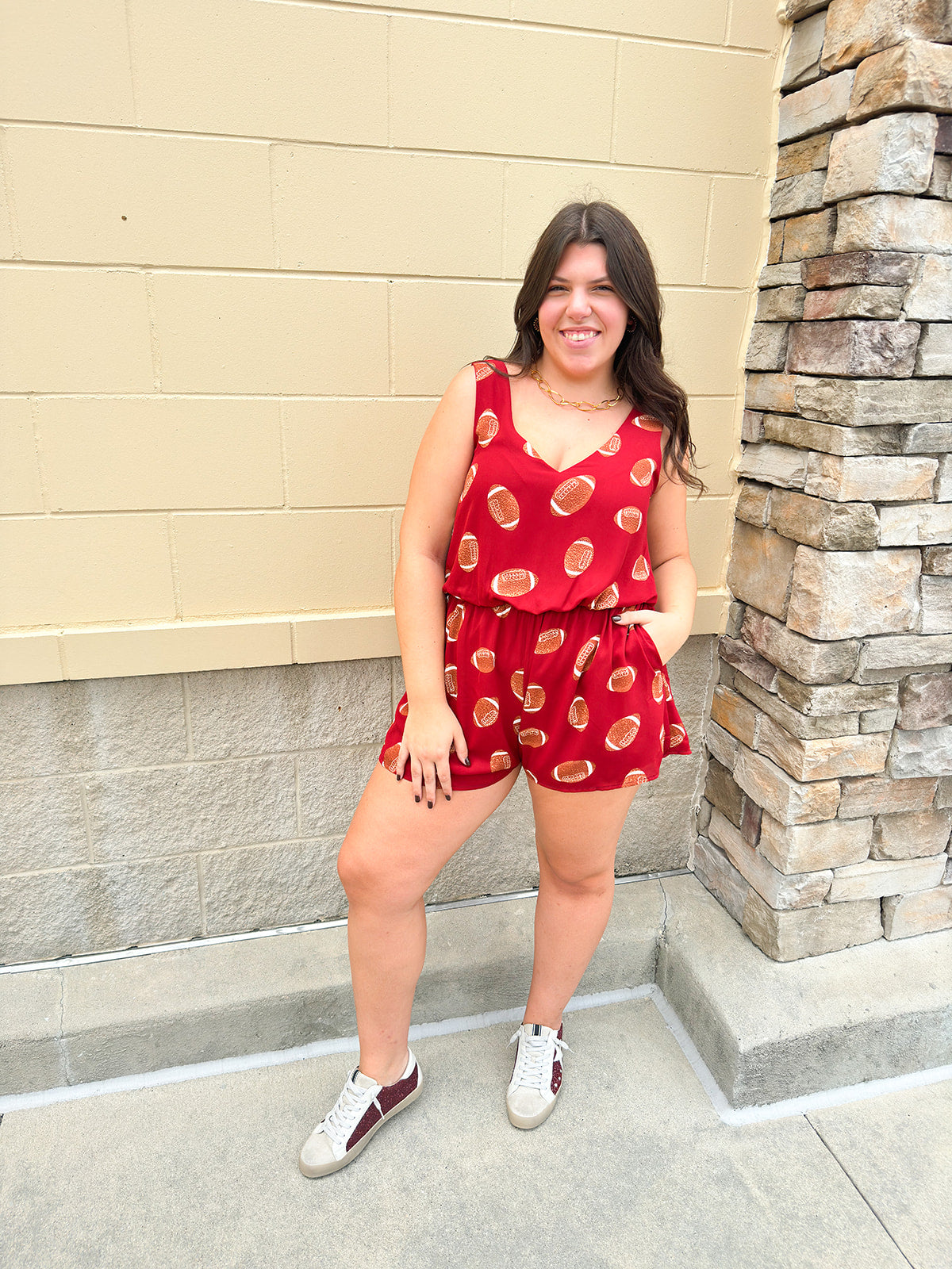 Garnet sleeveless romper with football print and side pockets, styled for game day