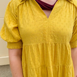 Mustard cotton mini dress with a collar, tiered A-line shape, and smocked cuff balloon sleeves—perfect for gameday style.