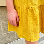 Mustard cotton mini dress with a collar, tiered A-line shape, and smocked cuff balloon sleeves—perfect for gameday style.