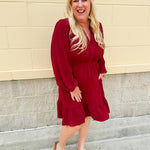 Garnet long sleeve woven mini dress with V-neckline, elastic waist, tiered hem, and pockets—lightweight and perfect for early fall wear