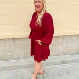 Garnet long sleeve woven mini dress with V-neckline, elastic waist, tiered hem, and pockets—lightweight and perfect for early fall wear