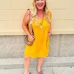 Sleeveless mustard cotton gauze dress with V-neckline, raw frayed edges, and front pockets. Lightweight and casual—ideal for Gameday or fall outings.