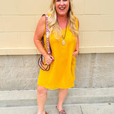 Sleeveless mustard cotton gauze dress with V-neckline, raw frayed edges, and front pockets. Lightweight and casual—ideal for Gameday or fall outings.