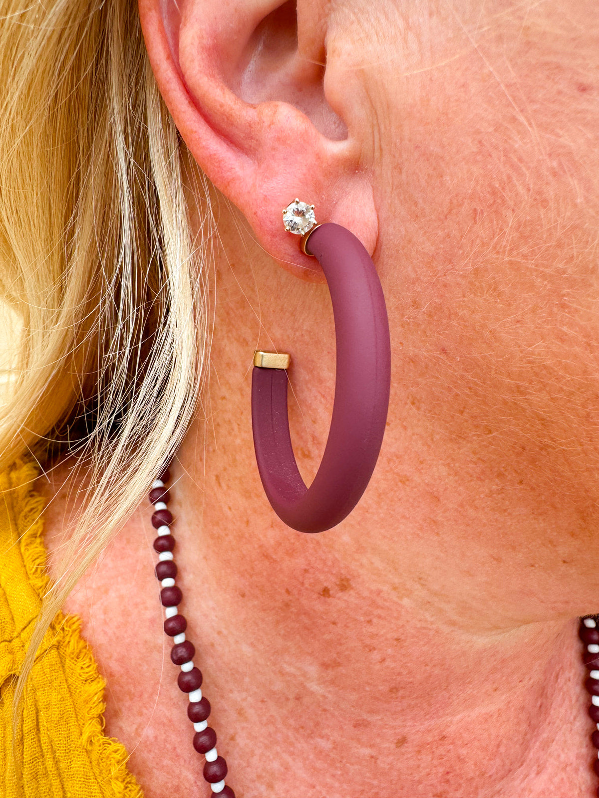 Gold-framed earrings with bold garnet centers available in small, medium, and large sizes—perfect for Gameday or holiday style.