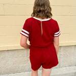 Garnet knit romper with white contrast trim on neckline, sleeves, and chest pocket. Features half sleeves, elastic waist, and keyhole back—sporty and stylish.