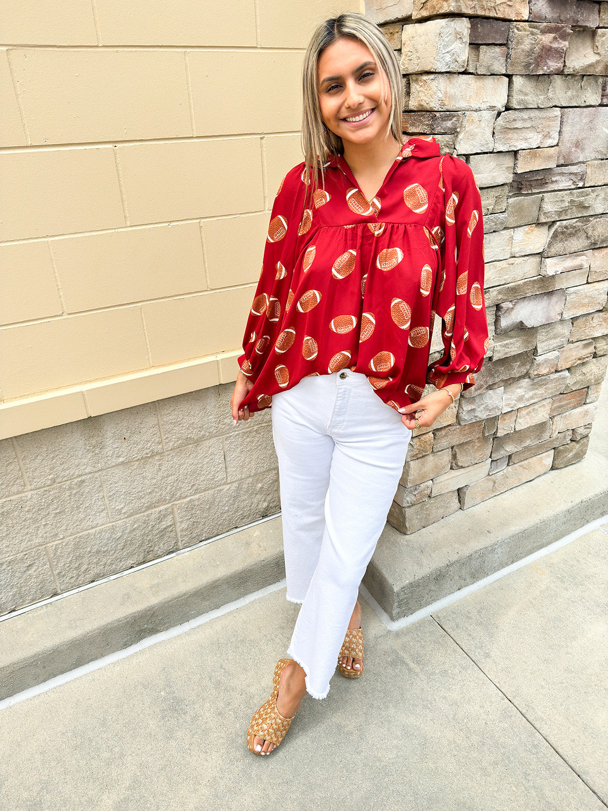 Garnet long sleeve top with football print and high ruffle collar, styled for game day
