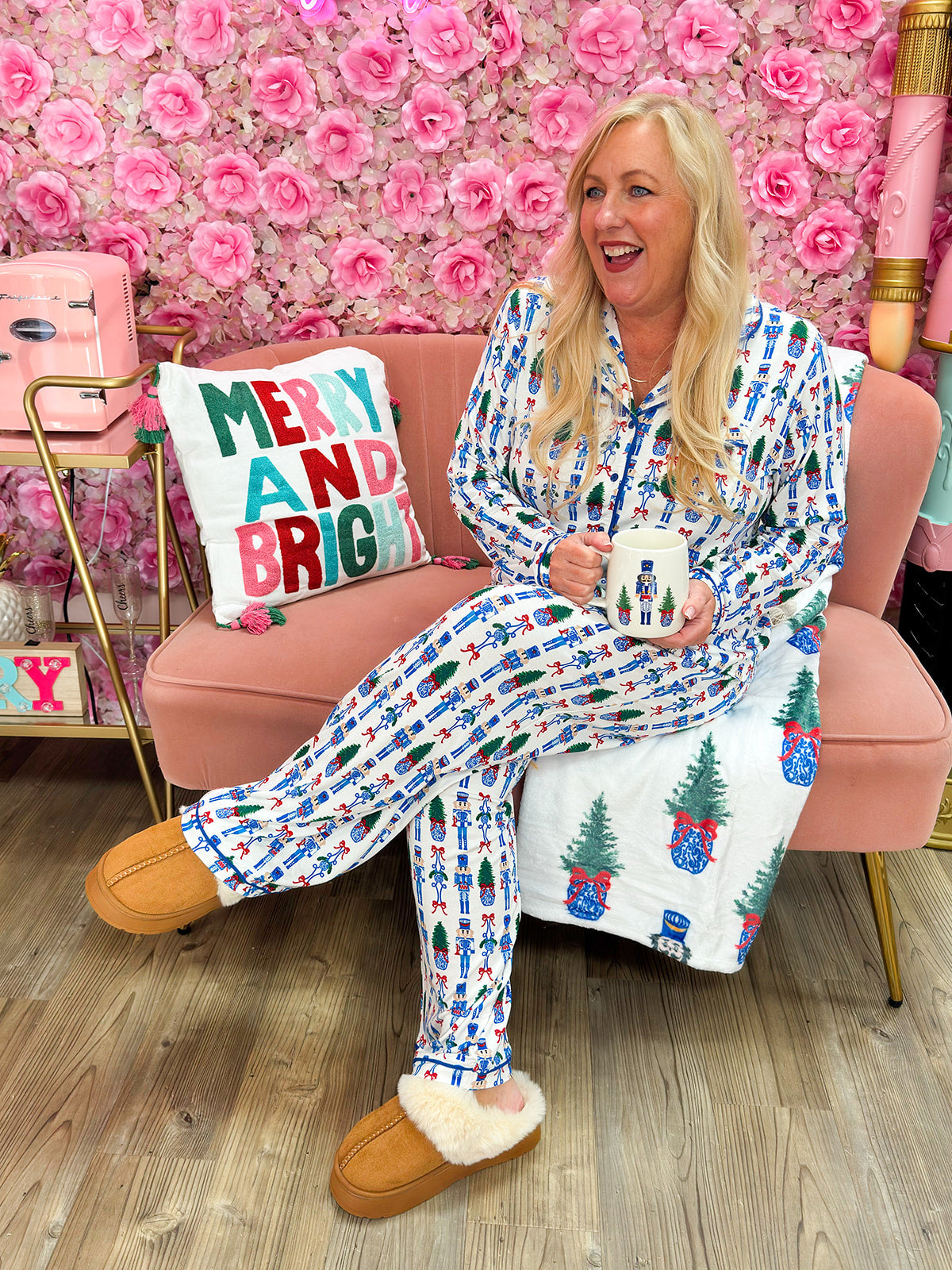 White pajama set with nutcracker and Christmas tree print, blue piping, and drawstring pants.