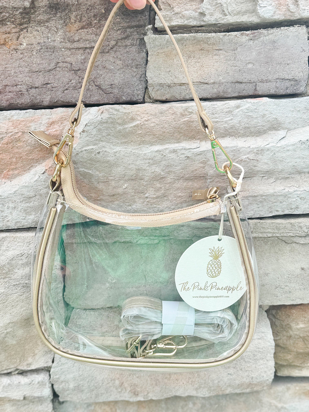 Clear stadium-approved crossbody purse with gold hardware and two strap options, perfect for game days or concerts.