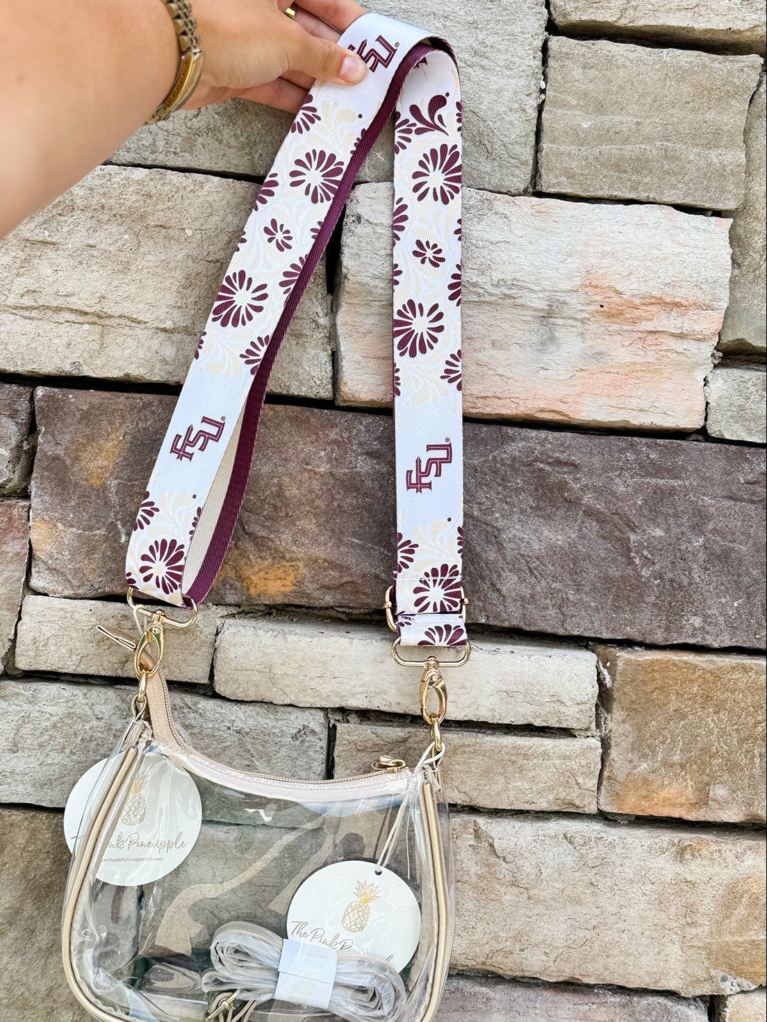 Reversible garnet and gold FSU bag strap with floral print and stripes, featuring brass hardware.