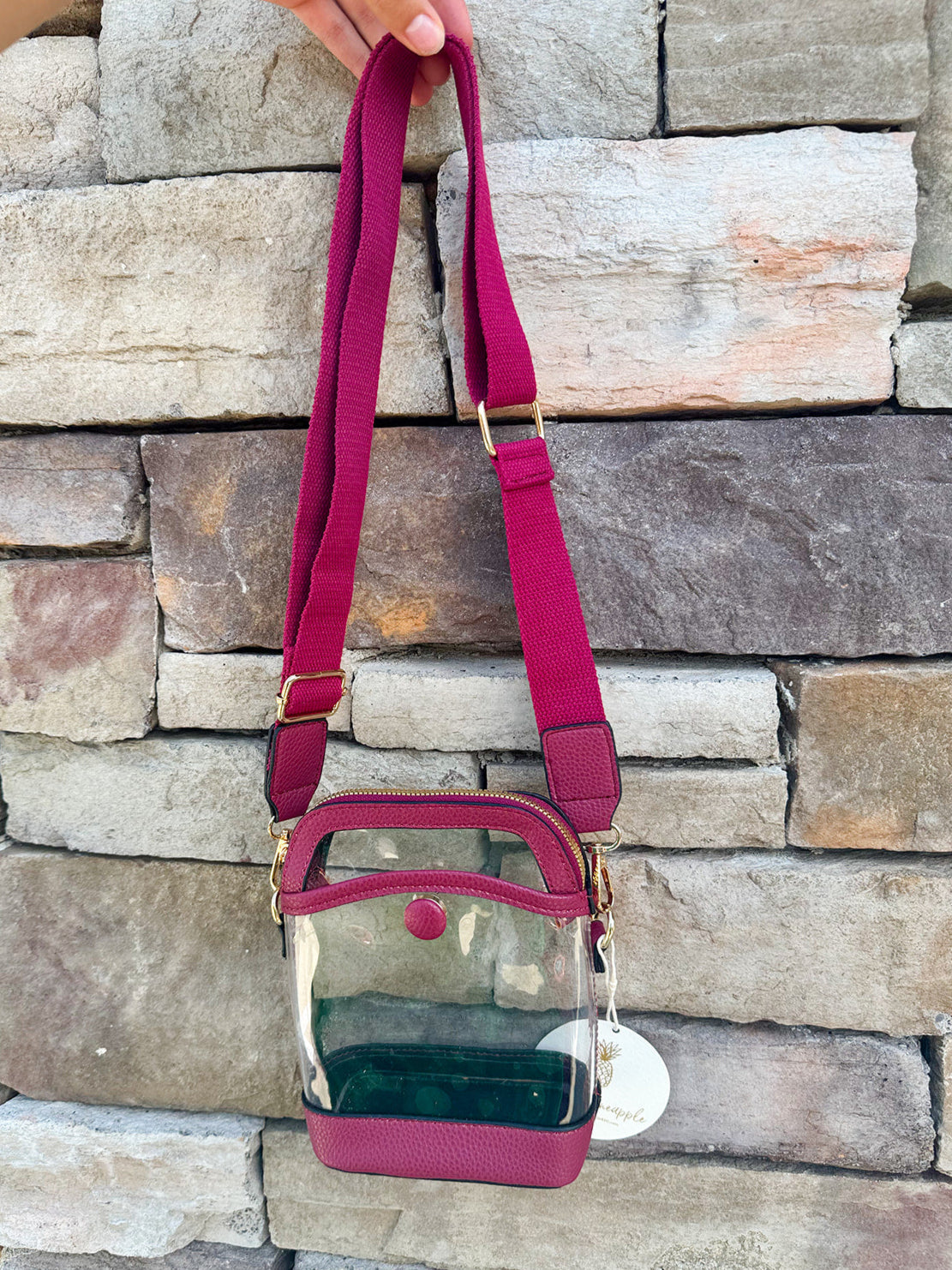 Garnet-trimmed clear stadium bag with zipper closure, top handle, and adjustable crossbody strap.