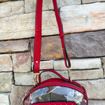 Clear football-shaped crossbody bag with garnet trim, zipper closure, and adjustable straps.