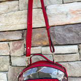 Clear football-shaped crossbody bag with garnet trim, zipper closure, and adjustable straps.