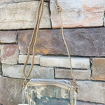 Clear crossbody purse with gold vegan leather trim and brass hardware, perfect for stadium entry and stylish events.
