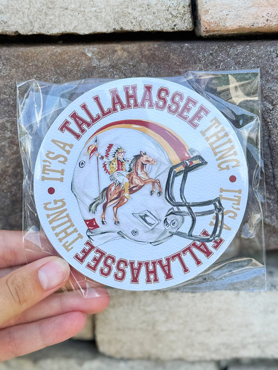 Round coasters with Renegade and Osceola on a football helmet framed by “It’s a Tallahassee Thing,” with garnet-and-gold pattern on the reverse.