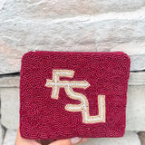 Maroon beaded clutch with FSU logo held against a stone wall.